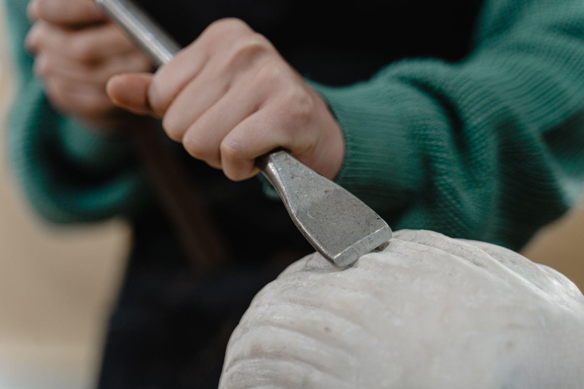 Mano di artigiano che incide la pietra con precisione